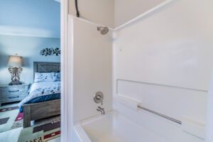 Shower and bedroom view with bed.