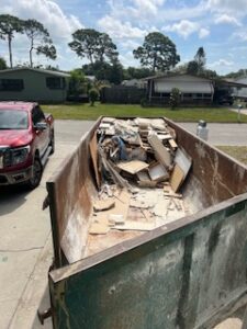 Dumpster filled with construction debris on street.