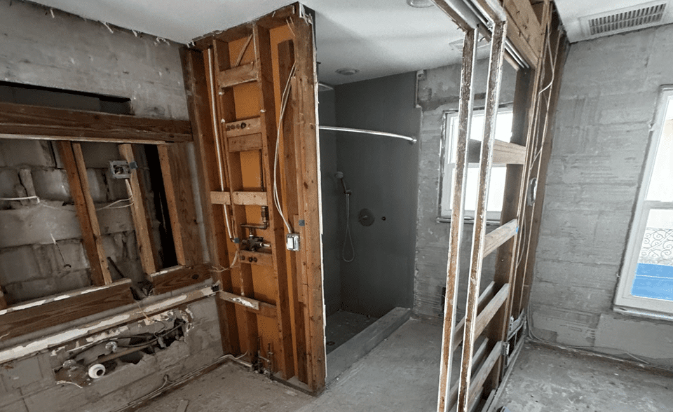 Bathroom under renovation with exposed wooden framing.